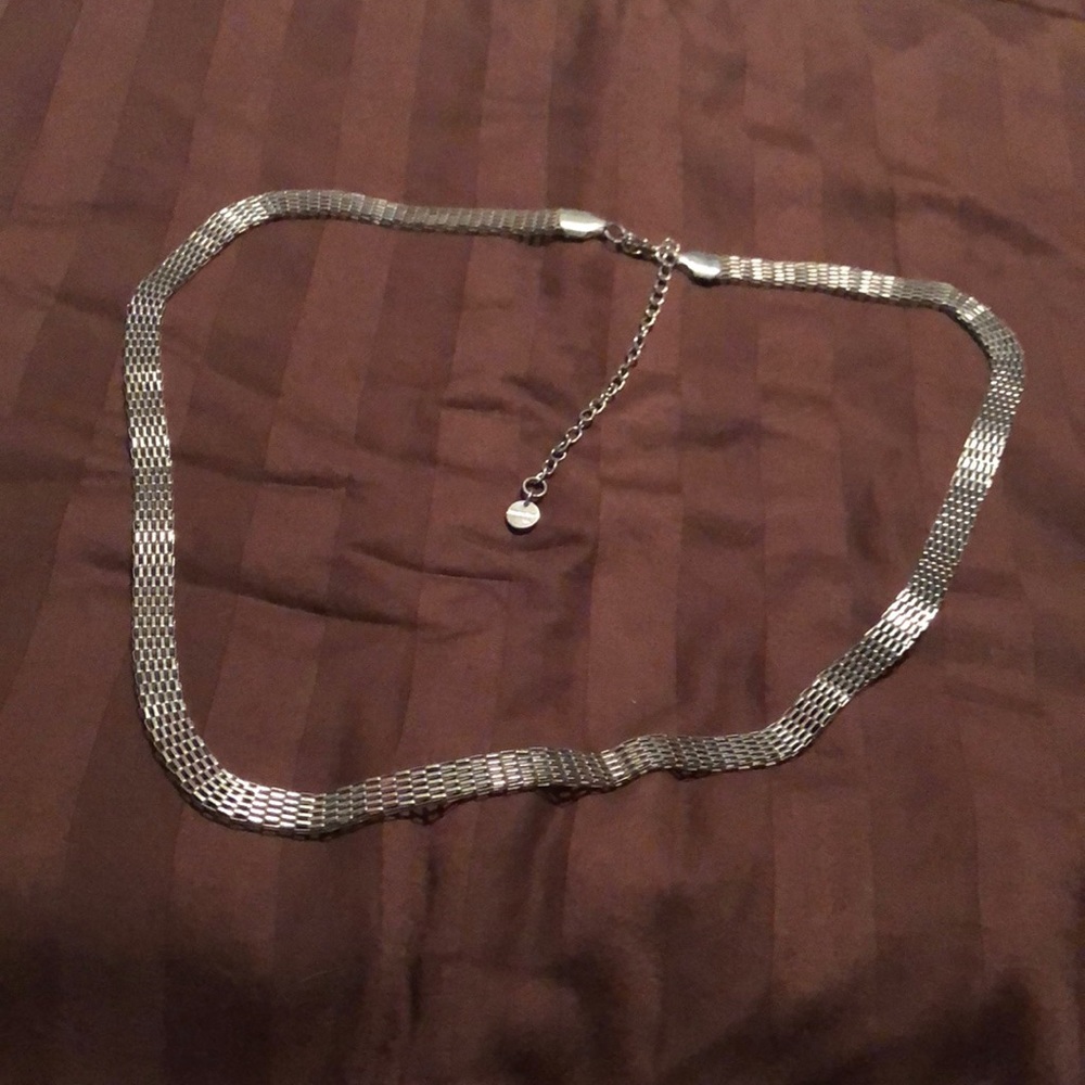 Jennifer Lopez. Silver tone necklace, possibly a belt.